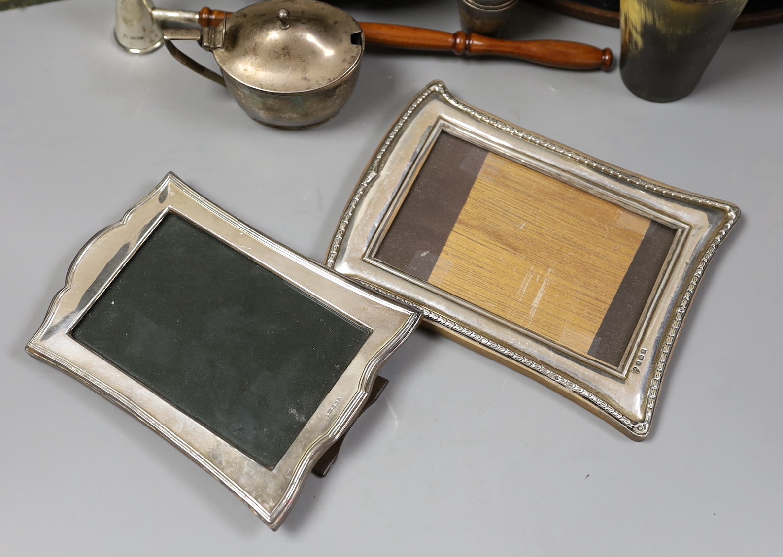 Assorted silver and other items including two silver mounted photograph frames, a Georgian silver mustard by John Eames, a graduated suite of three Victorian silver mounted horn beakers, a silver candle extinguisher, a c